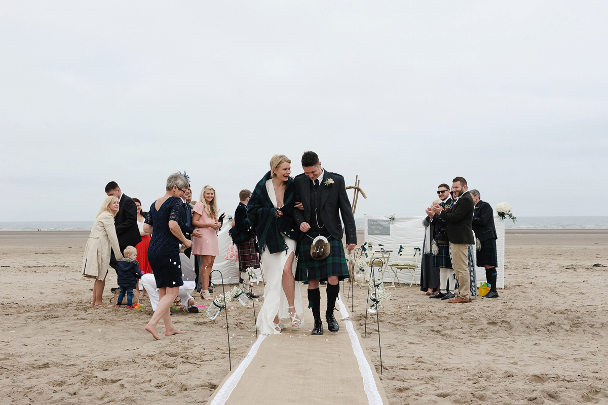 Laura wears a 1970's inspired Stone Cold Fox wedding dress for her laid back and organic beach wedding in Scotland. Photography by Tino and Pip.