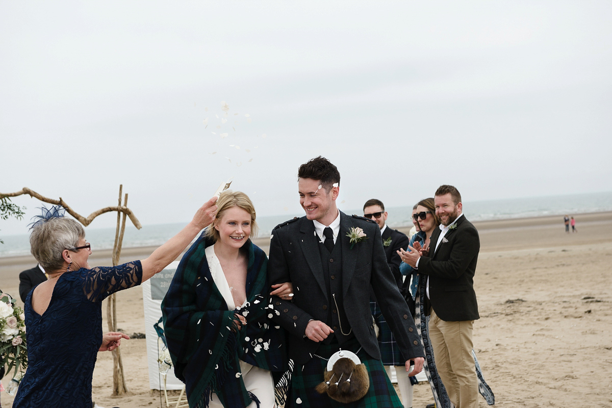 Laura wears a 1970's inspired Stone Cold Fox wedding dress for her laid back and organic beach wedding in Scotland. Photography by Tino and Pip.