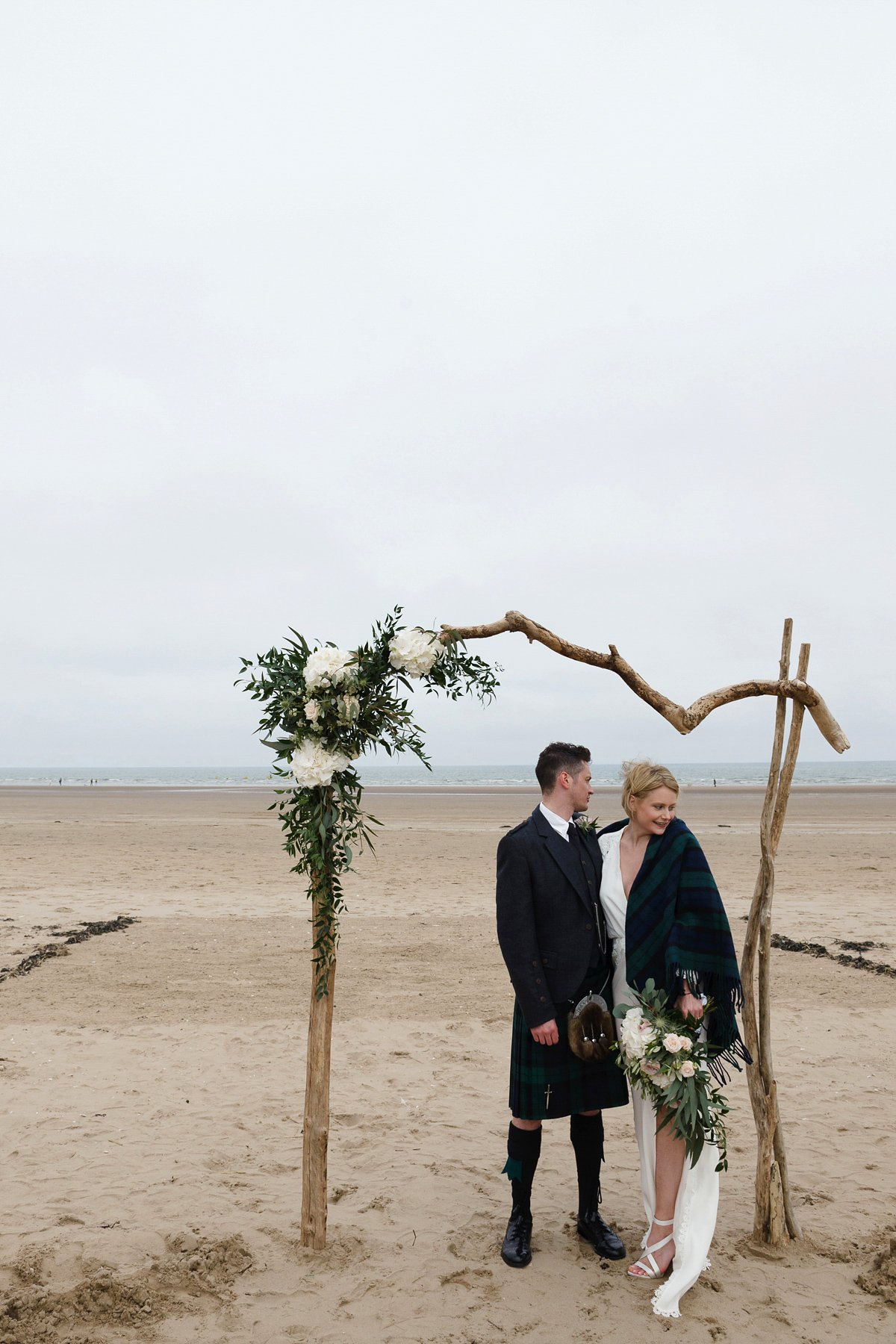 Laura wears a 1970's inspired Stone Cold Fox wedding dress for her laid back and organic beach wedding in Scotland. Photography by Tino and Pip.