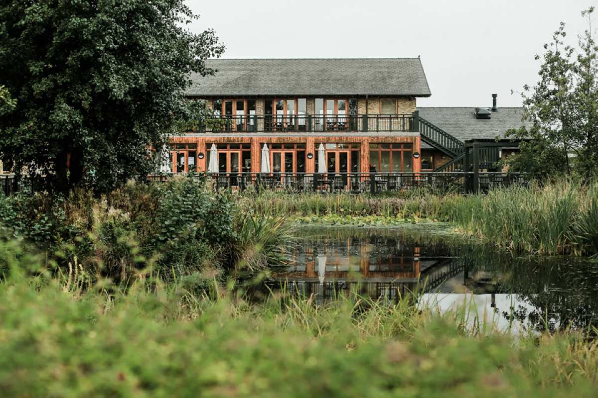 Gillian wore a short lace John Lewis wedding dress and a feather in her hair for her nature inspired Autumn wedding at London Wetlands Centre. Images by Kristida Photography.