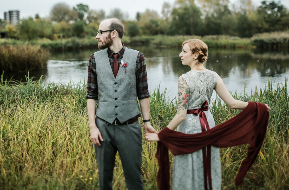 Gillian wore a short lace John Lewis wedding dress and a feather in her hair for her nature inspired Autumn wedding at London Wetlands Centre. Images by Kristida Photography.