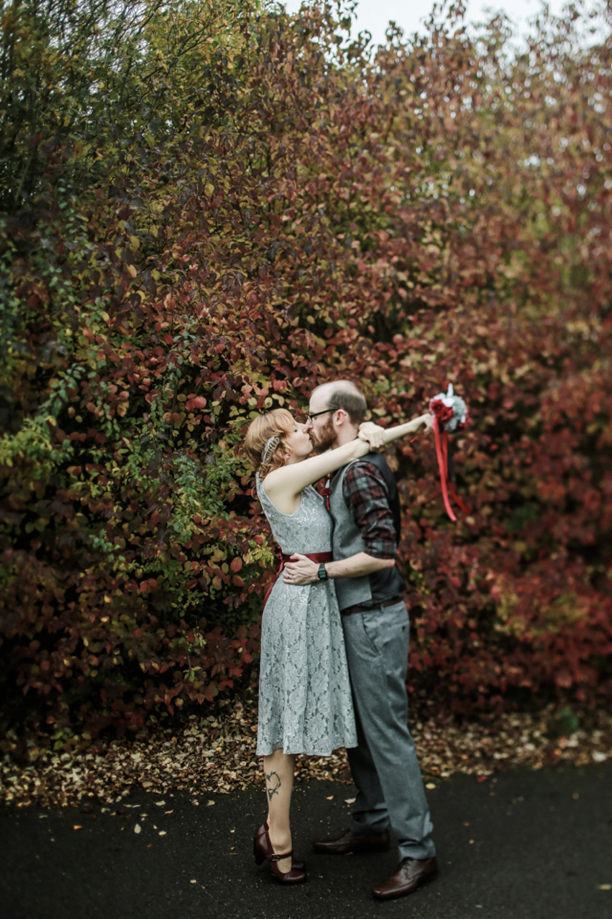 Gillian wore a short lace John Lewis wedding dress and a feather in her hair for her nature inspired Autumn wedding at London Wetlands Centre. Images by Kristida Photography.