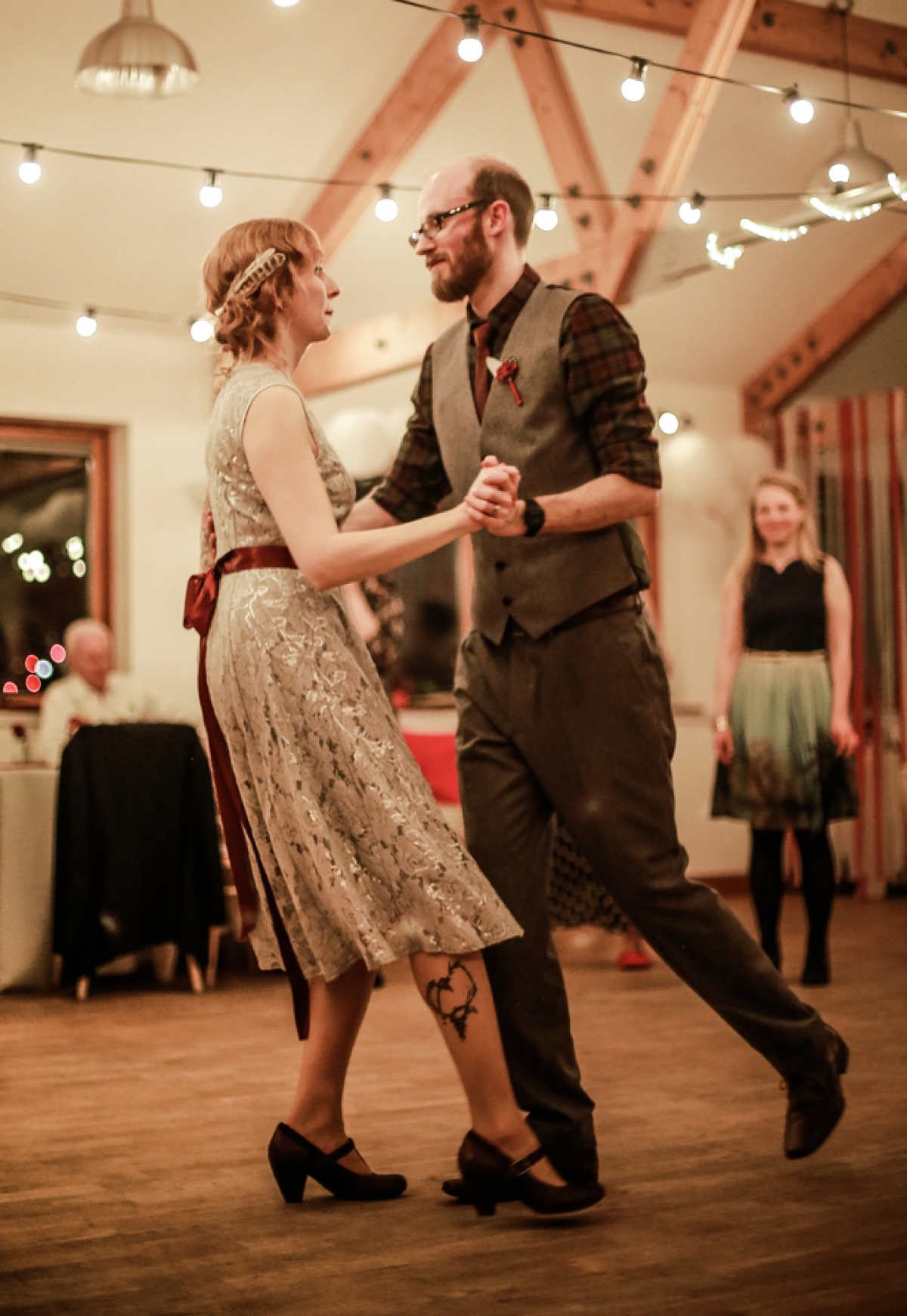 Gillian wore a short lace John Lewis wedding dress and a feather in her hair for her nature inspired Autumn wedding at London Wetlands Centre. Images by Kristida Photography.