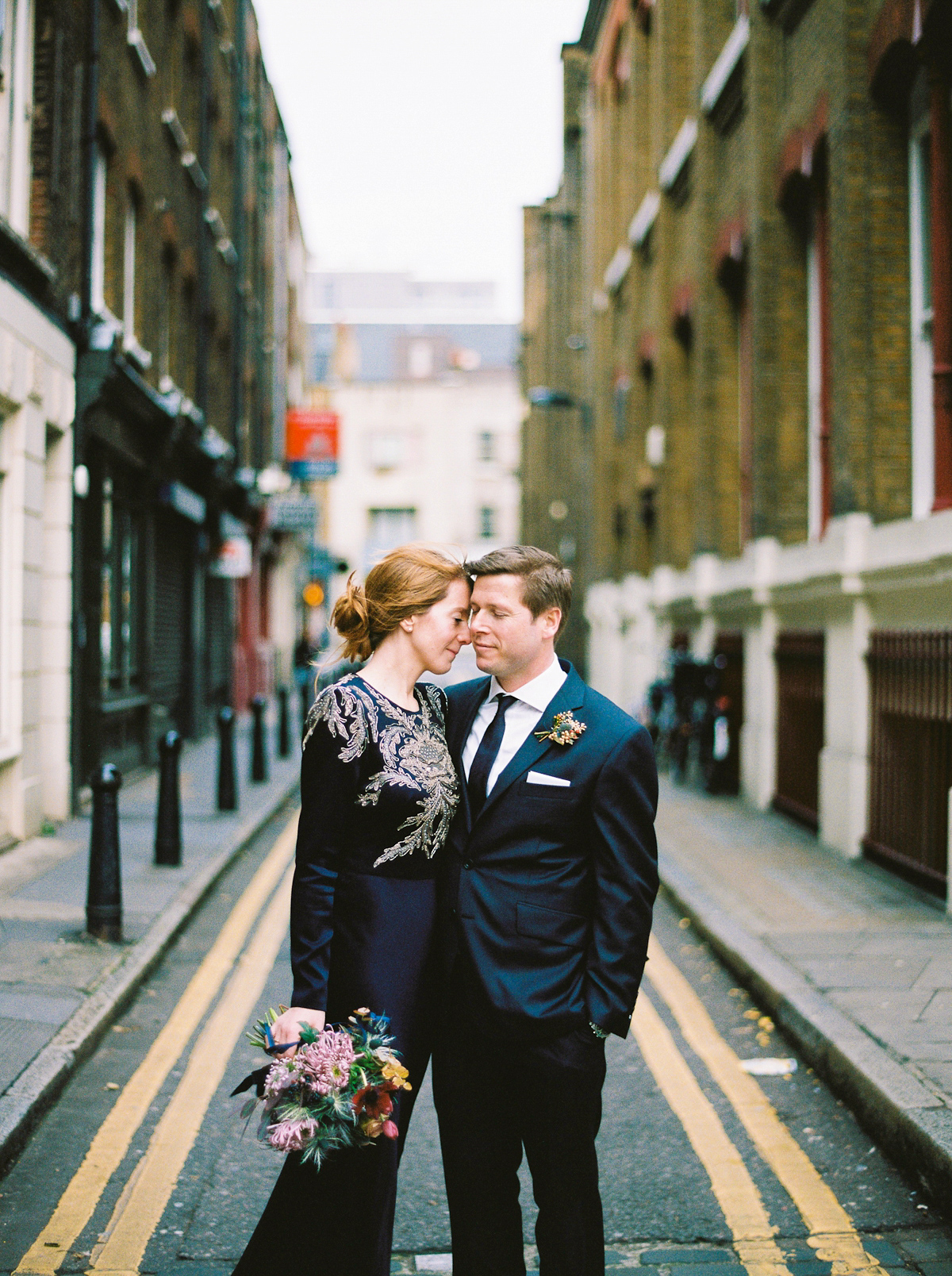 Leanne wears a navy blue Alexander McQueen dress for her modern and stylish, non traditional London wedding. A First look wedding captured on film by Peachey Photography.