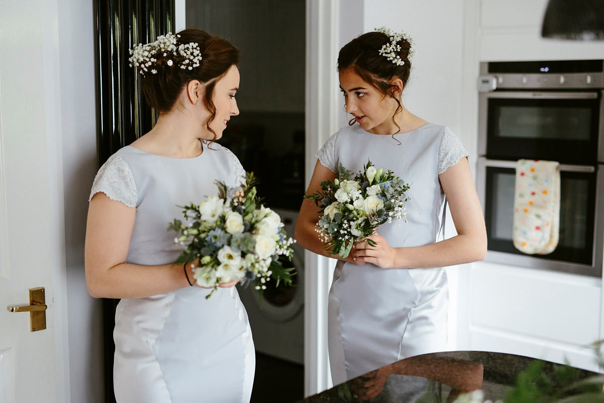An elegant halterneck dress and bridesmaids in pale blue for a stylish English country wedding. Captured by Ruth Atkins Photography.