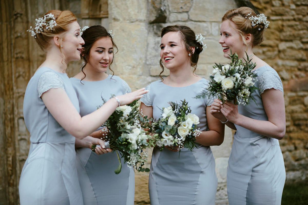 An elegant halterneck dress and bridesmaids in pale blue for a stylish English country wedding. Captured by Ruth Atkins Photography.