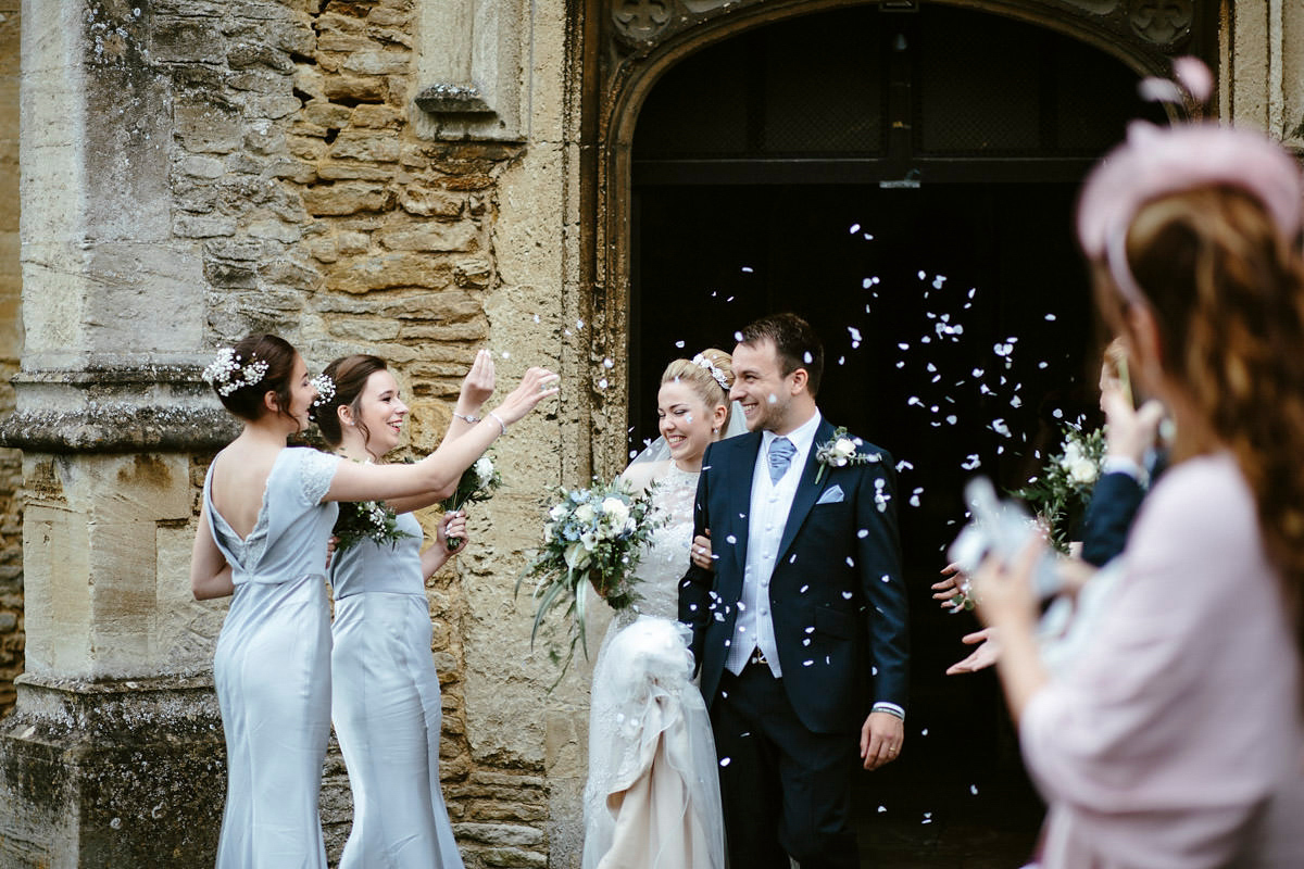 An elegant halterneck dress and bridesmaids in pale blue for a stylish English country wedding. Captured by Ruth Atkins Photography.
