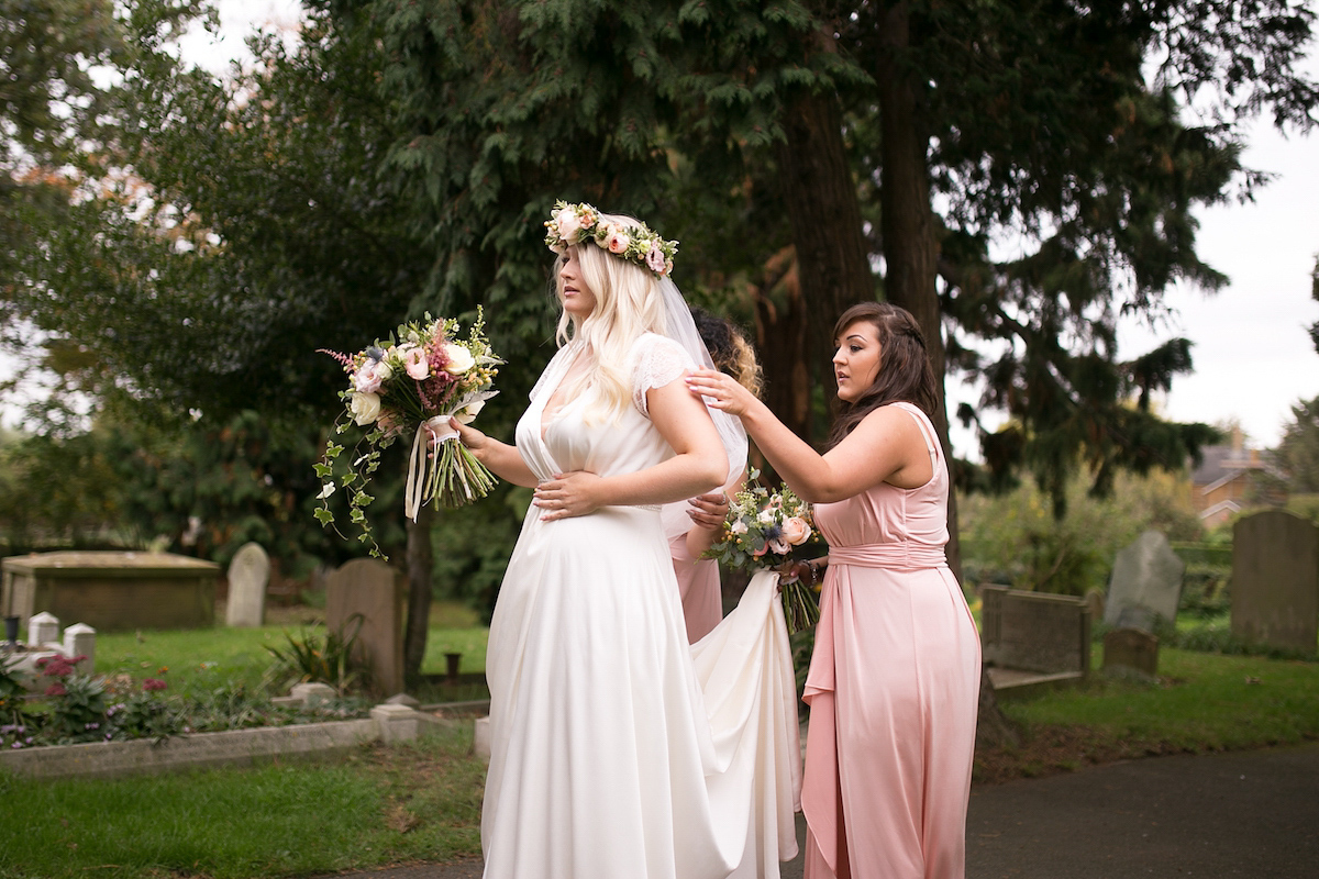 Bride Laura wore a Charlie Brear gown and floral crown for her charming Autumn village hall wedding. Photography by Henry Britten.