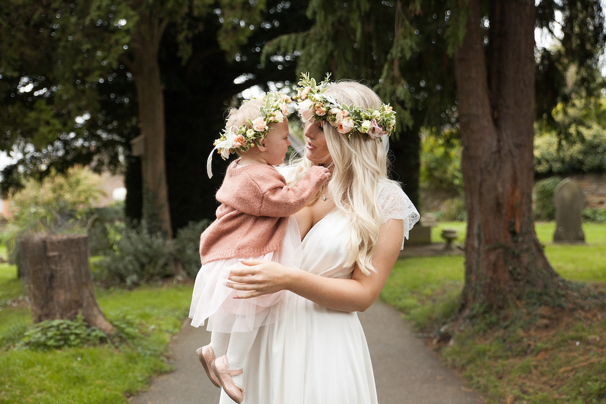 Bride Laura wore a Charlie Brear gown and floral crown for her charming Autumn village hall wedding. Photography by Henry Britten.