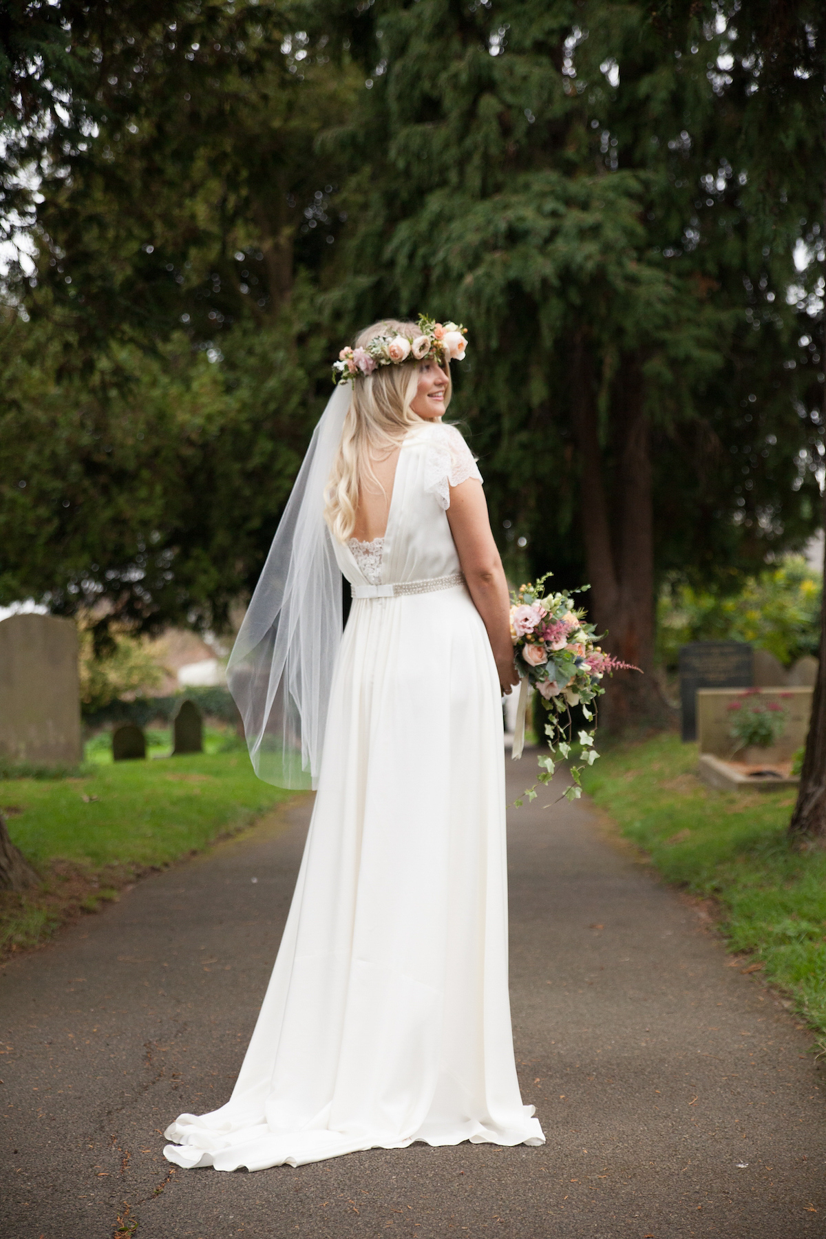 Bride Laura wore a Charlie Brear gown and floral crown for her charming Autumn village hall wedding. Photography by Henry Britten.