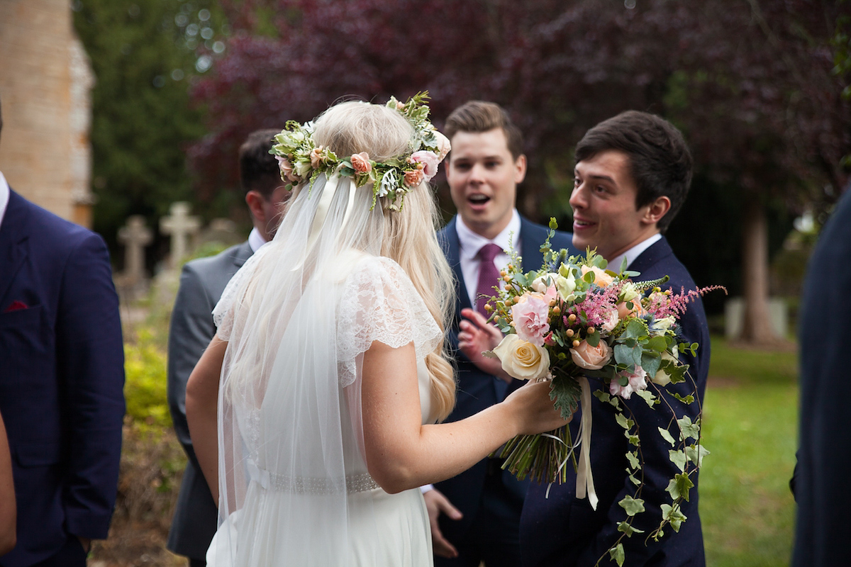 Bride Laura wore a Charlie Brear gown and floral crown for her charming Autumn village hall wedding. Photography by Henry Britten.