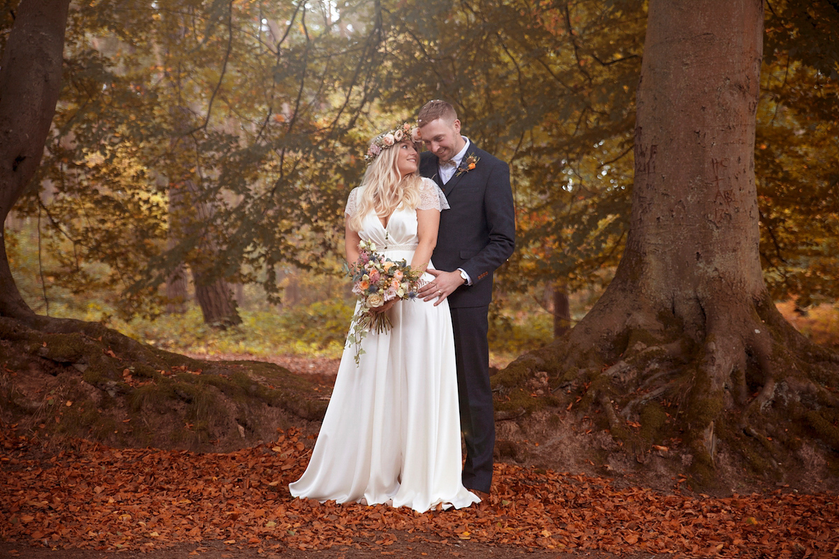 Bride Laura wore a Charlie Brear gown and floral crown for her charming Autumn village hall wedding. Photography by Henry Britten.