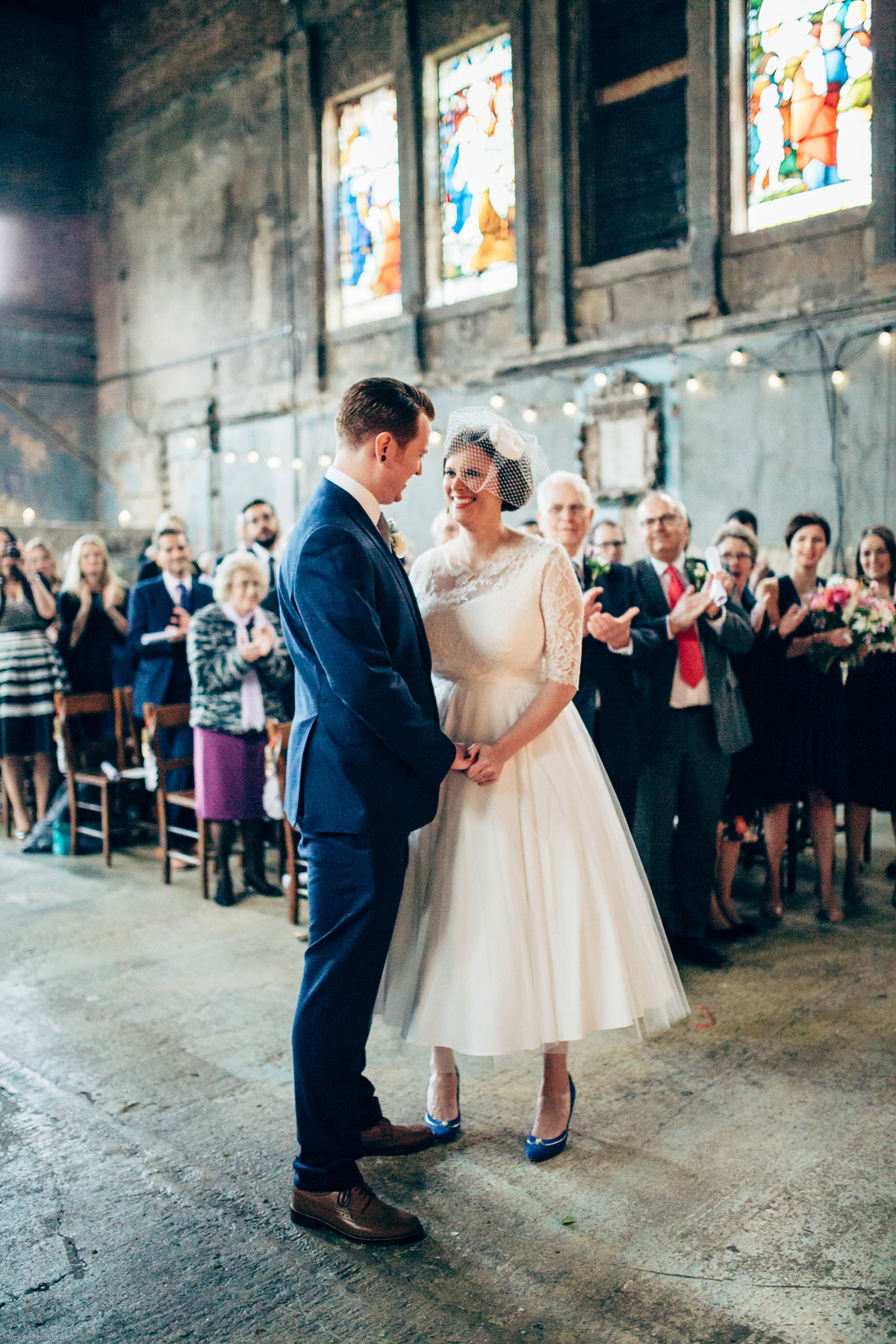 Bride Dany wears a 1950's inspired lace dress and birdcage veil for her modern cool wedding at The Asylum. Their reception was held in a London pub. Photography by Naomi Jane.