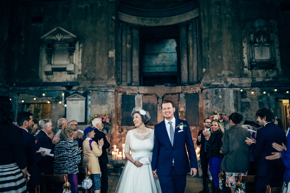 Bride Dany wears a 1950's inspired lace dress and birdcage veil for her modern cool wedding at The Asylum. Their reception was held in a London pub. Photography by Naomi Jane.