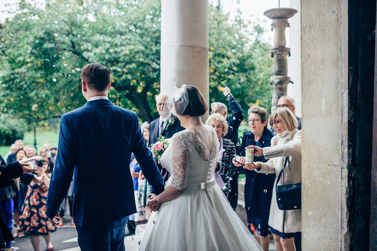 Bride Dany wears a 1950's inspired lace dress and birdcage veil for her modern cool wedding at The Asylum. Their reception was held in a London pub. Photography by Naomi Jane.