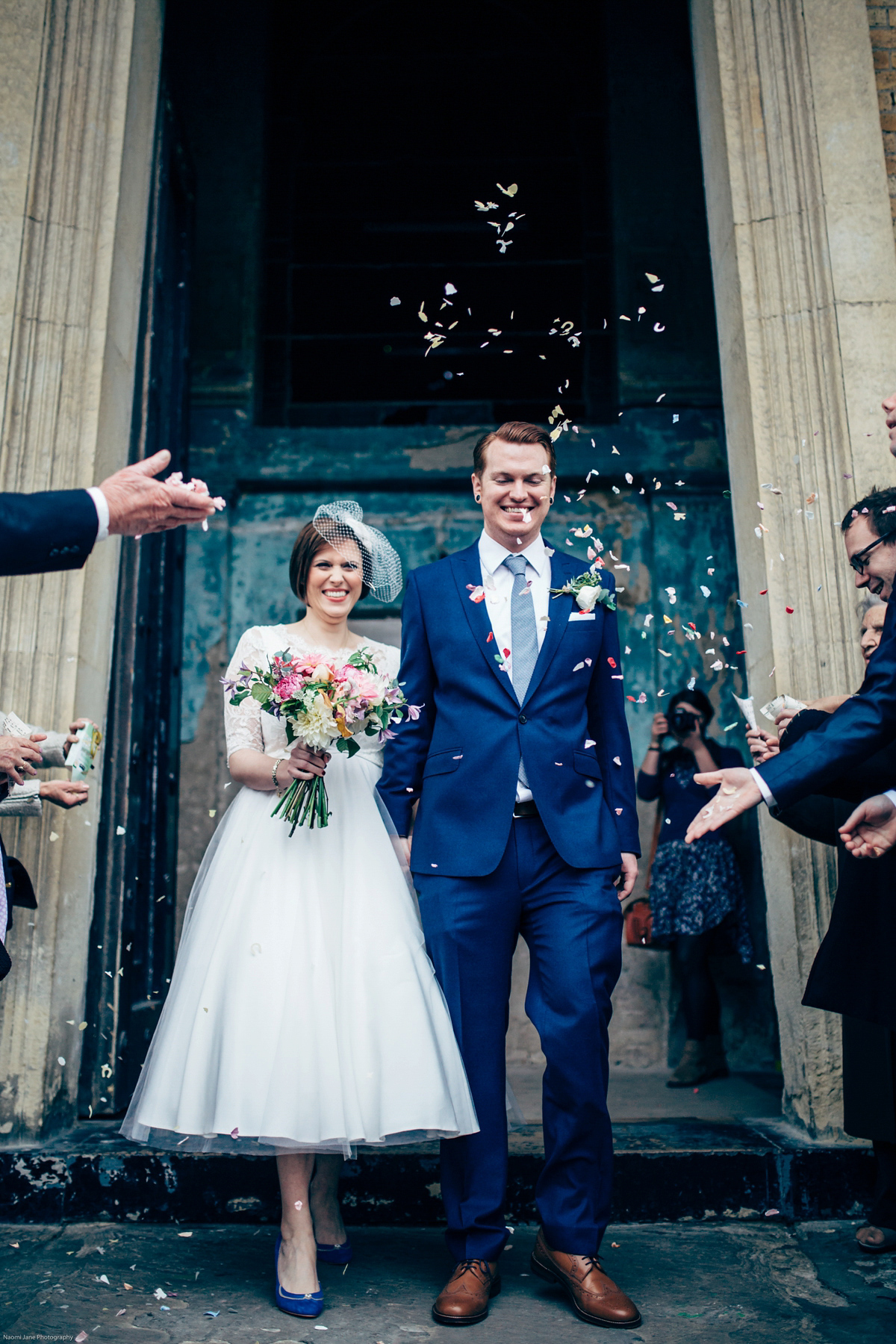 Bride Dany wears a 1950's inspired lace dress and birdcage veil for her modern cool wedding at The Asylum. Their reception was held in a London pub. Photography by Naomi Jane.