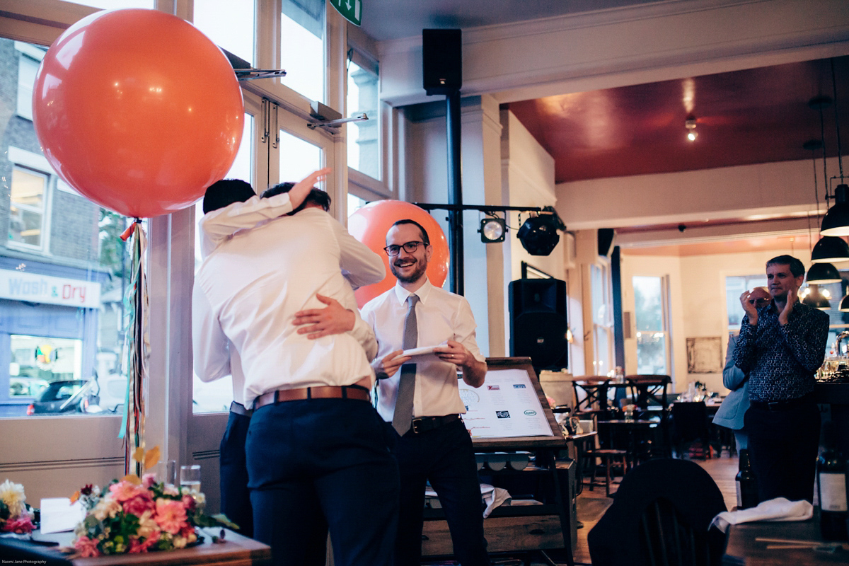 Bride Dany wears a 1950's inspired lace dress and birdcage veil for her modern cool wedding at The Asylum. Their reception was held in a London pub. Photography by Naomi Jane.