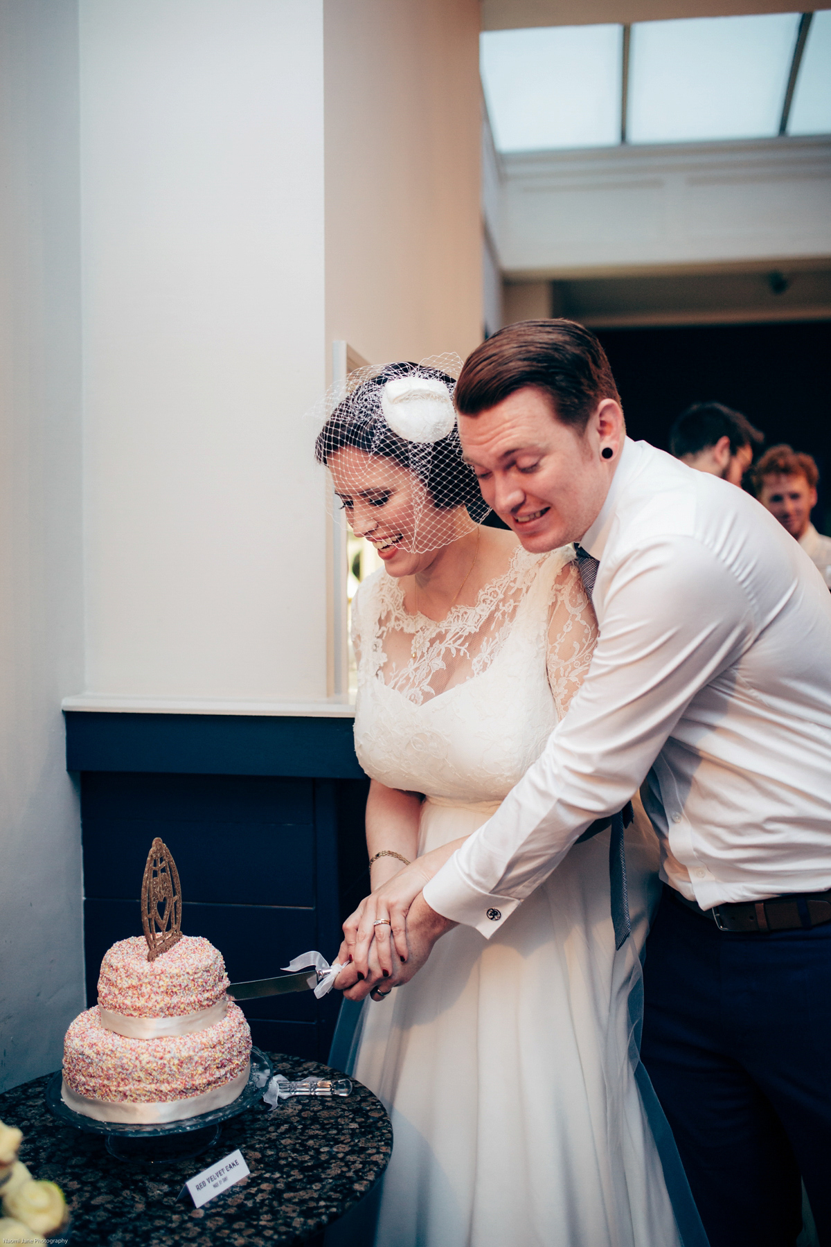 Bride Dany wears a 1950's inspired lace dress and birdcage veil for her modern cool wedding at The Asylum. Their reception was held in a London pub. Photography by Naomi Jane.