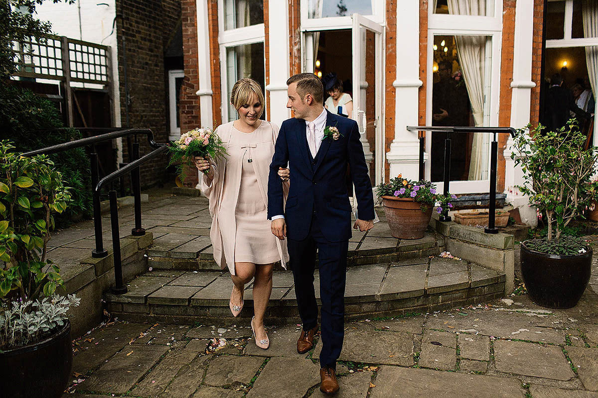 Celine wore a short, chic, pale pink wedding dress for her non-traditional wedding at the Greenwich Yacht Club in London. Captured by Paul Joseph Photography.
