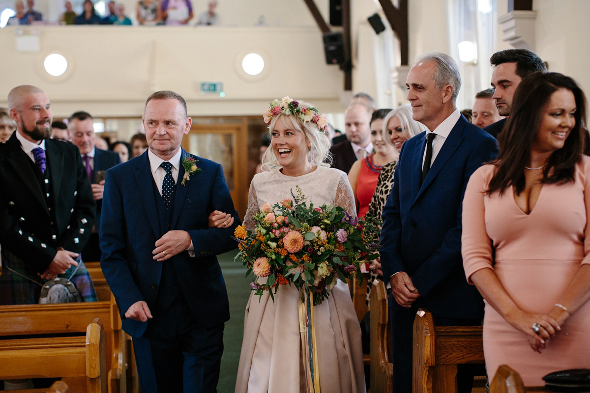 Bride Emma-Jane wore a pale pink skirt and lace top for her Scottish chapel wedding. Her maids wore pale blue and floral crowns. Photography by Caro Weiss.