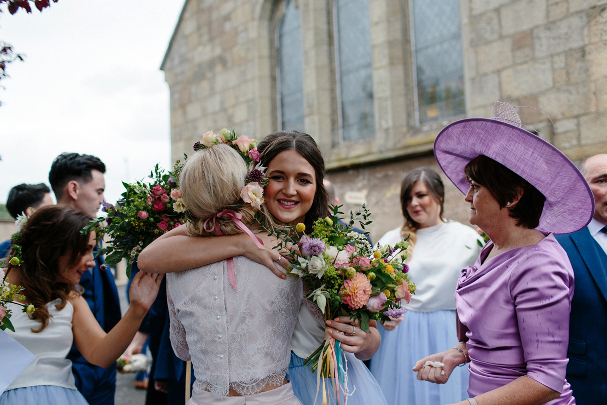 Bride Emma-Jane wore a pale pink skirt and lace top for her Scottish chapel wedding. Her maids wore pale blue and floral crowns. Photography by Caro Weiss.