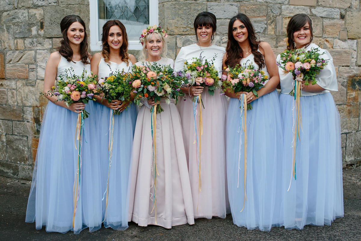 Bride Emma-Jane wore a pale pink skirt and lace top for her Scottish chapel wedding. Her maids wore pale blue and floral crowns. Photography by Caro Weiss.
