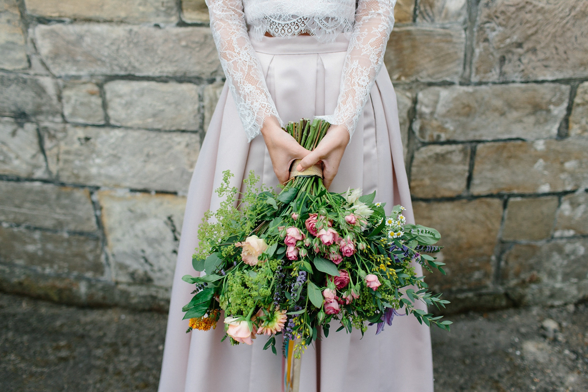 Bride Emma-Jane wore a pale pink skirt and lace top for her Scottish chapel wedding. Her maids wore pale blue and floral crowns. Photography by Caro Weiss.