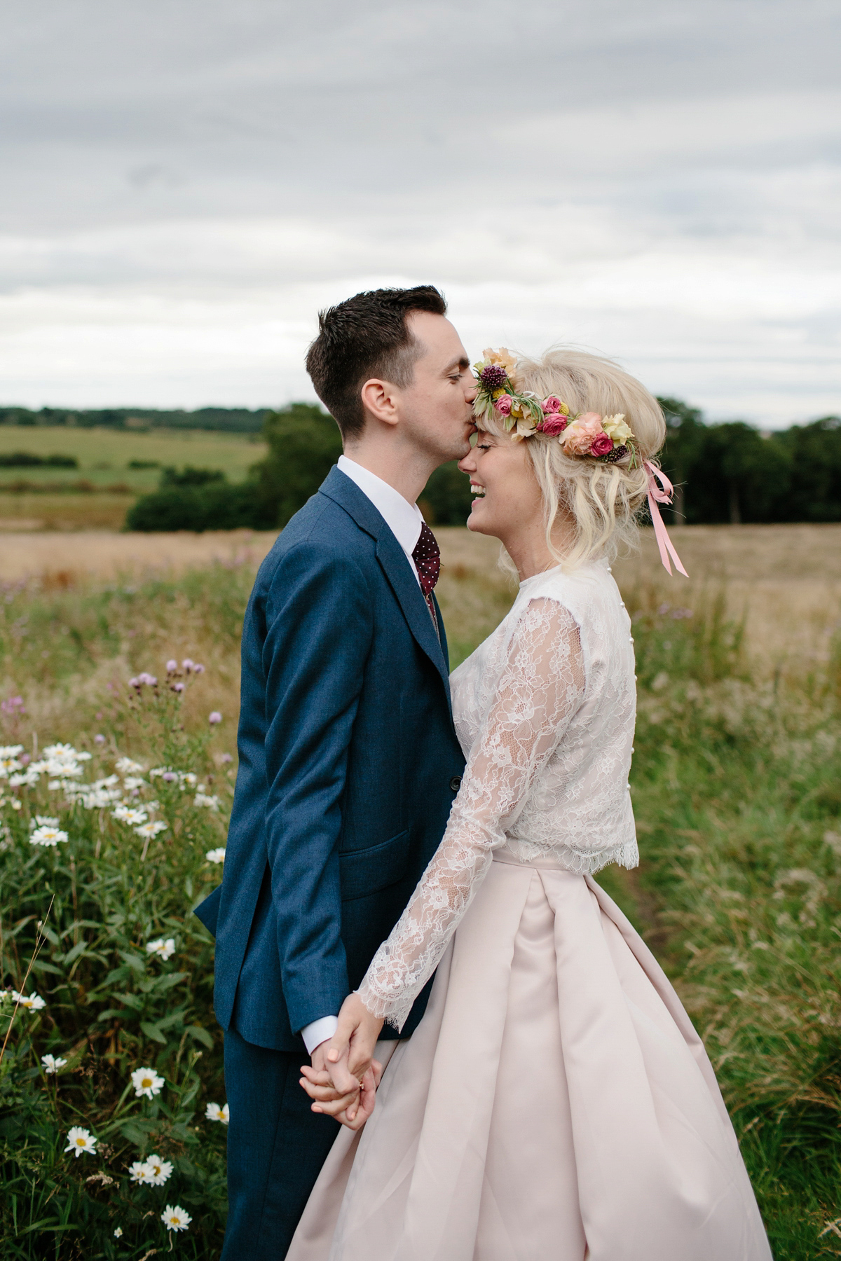 Bride Emma-Jane wore a pale pink skirt and lace top for her Scottish chapel wedding. Her maids wore pale blue and floral crowns. Photography by Caro Weiss.