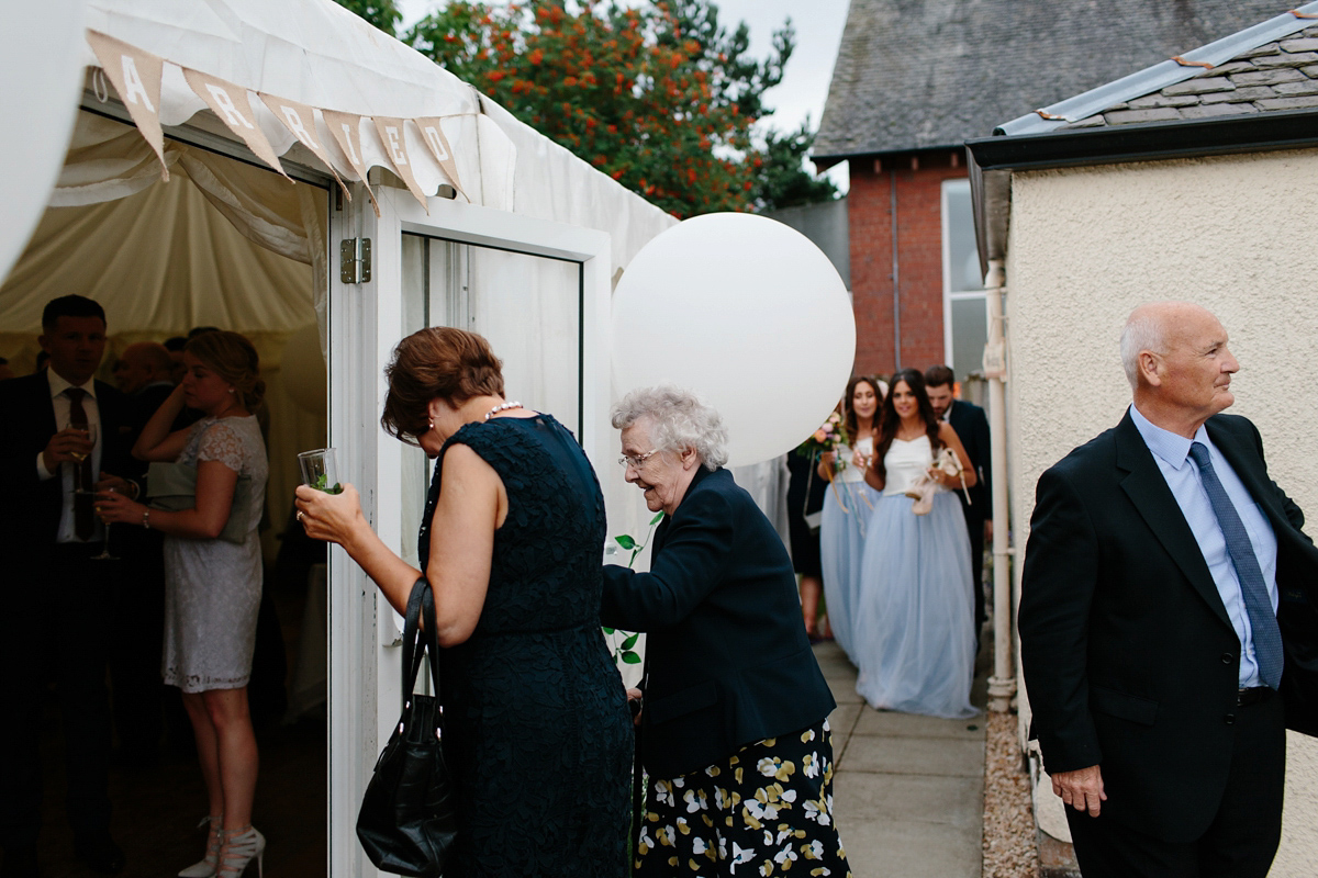 Bride Emma-Jane wore a pale pink skirt and lace top for her Scottish chapel wedding. Her maids wore pale blue and floral crowns. Photography by Caro Weiss.