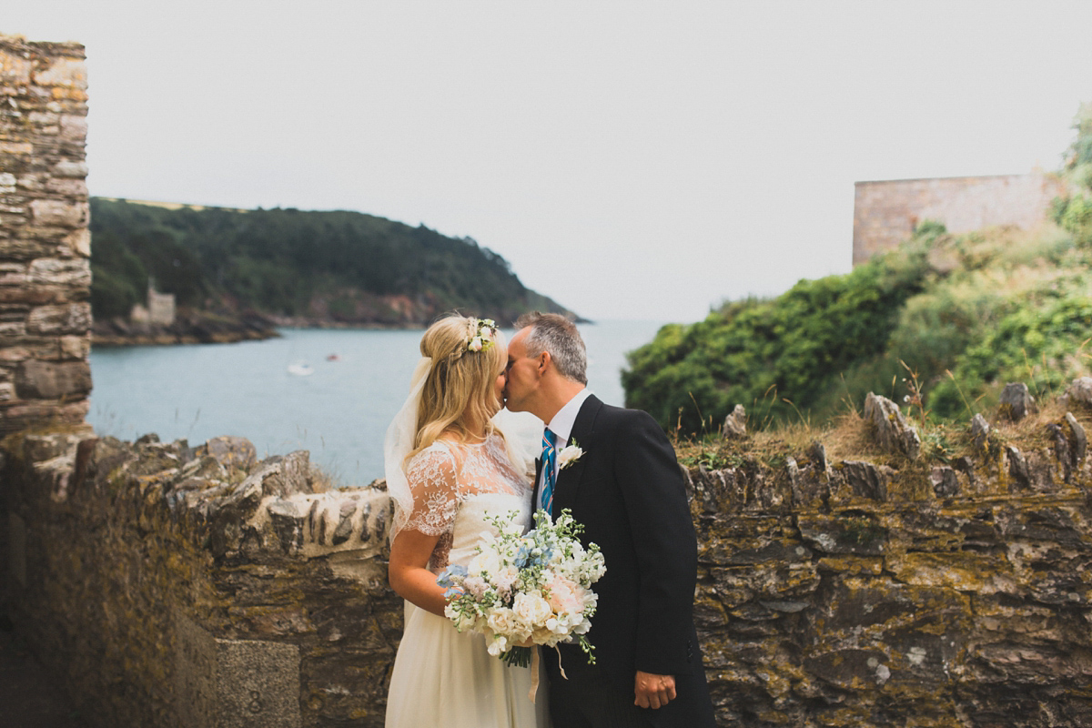 Rosie wore a Laure de Sagazan gown from The Mews of Notting Hill for her romantic summertime Devonshire coast wedding. Photography by Joseph Hall.