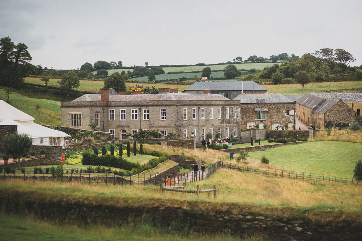 Rosie wore a Laure de Sagazan gown from The Mews of Notting Hill for her romantic summertime Devonshire coast wedding. Photography by Joseph Hall.