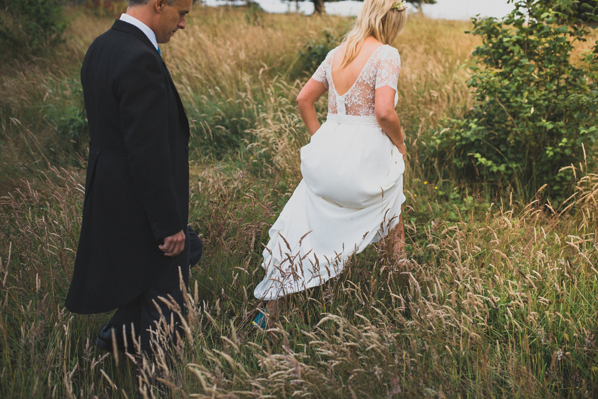 Rosie wore a Laure de Sagazan gown from The Mews of Notting Hill for her romantic summertime Devonshire coast wedding. Photography by Joseph Hall.