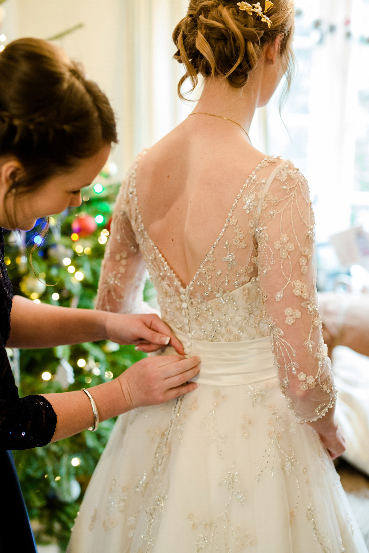 Katy wore a gold embroidered gown by Ronald Joyce for her glamorous winter wedding at Bath Assembly Rooms. Her bridesmaids wore navy blue. Photography by Lydia Stamps.