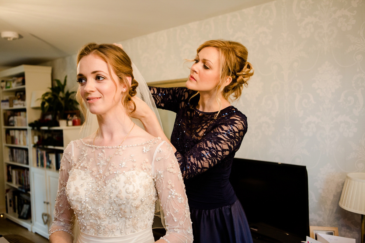 Katy wore a gold embroidered gown by Ronald Joyce for her glamorous winter wedding at Bath Assembly Rooms. Her bridesmaids wore navy blue. Photography by Lydia Stamps.