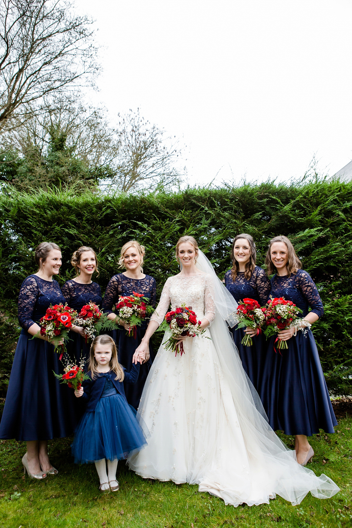 Katy wore a gold embroidered gown by Ronald Joyce for her glamorous winter wedding at Bath Assembly Rooms. Her bridesmaids wore navy blue. Photography by Lydia Stamps.