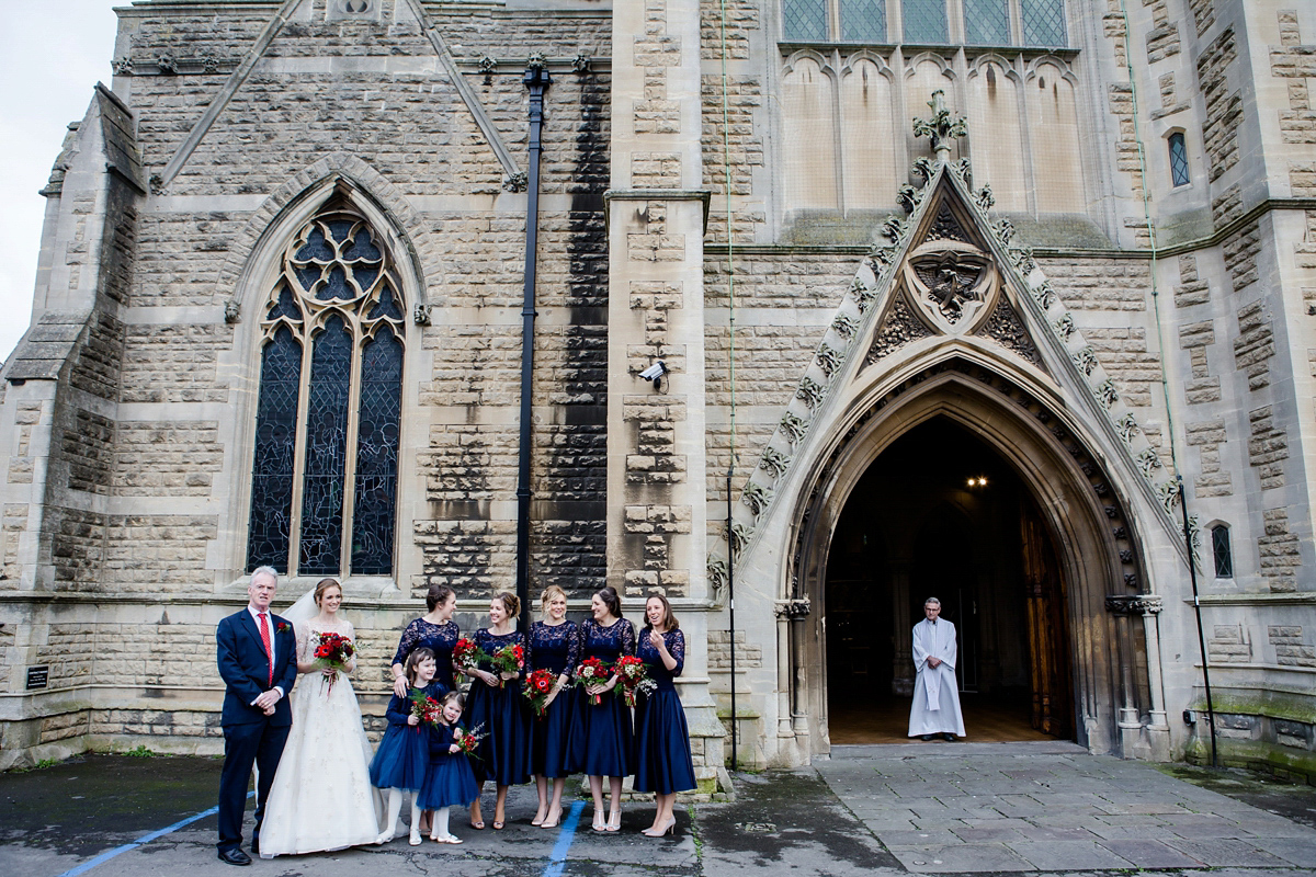 Katy wore a gold embroidered gown by Ronald Joyce for her glamorous winter wedding at Bath Assembly Rooms. Her bridesmaids wore navy blue. Photography by Lydia Stamps.