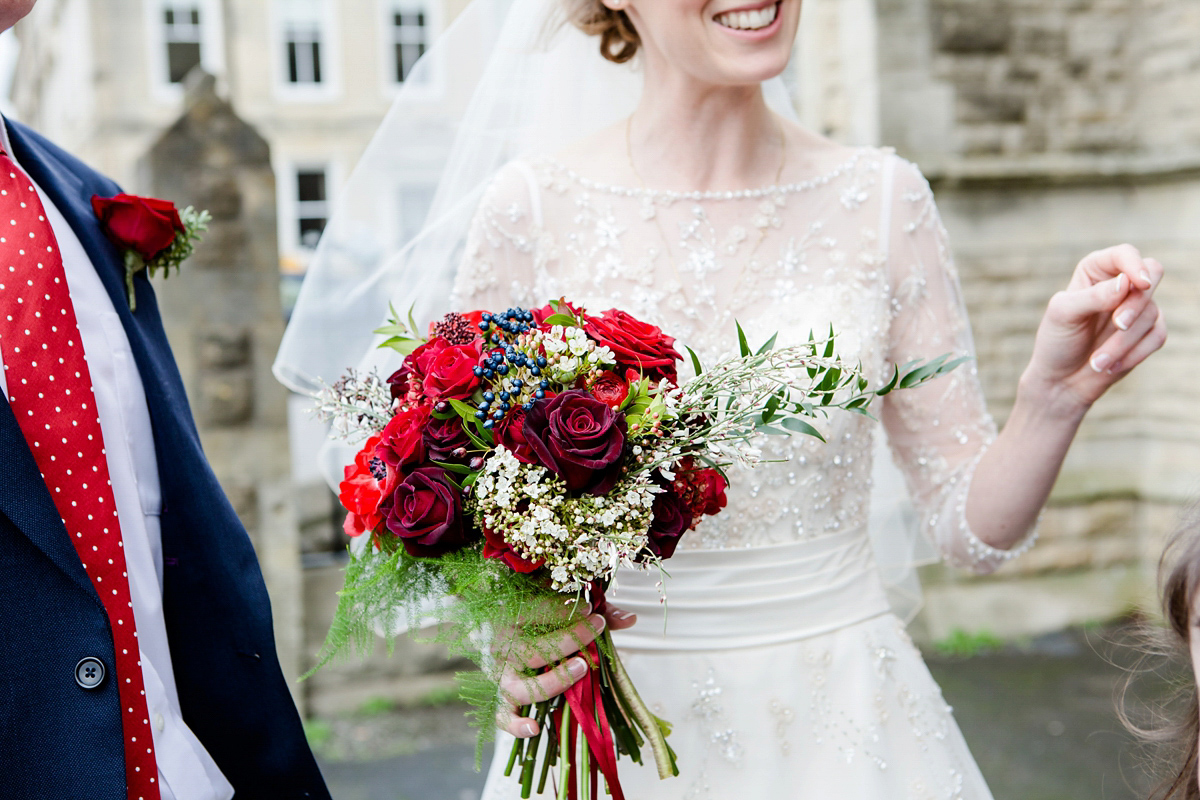 Katy wore a gold embroidered gown by Ronald Joyce for her glamorous winter wedding at Bath Assembly Rooms. Her bridesmaids wore navy blue. Photography by Lydia Stamps.