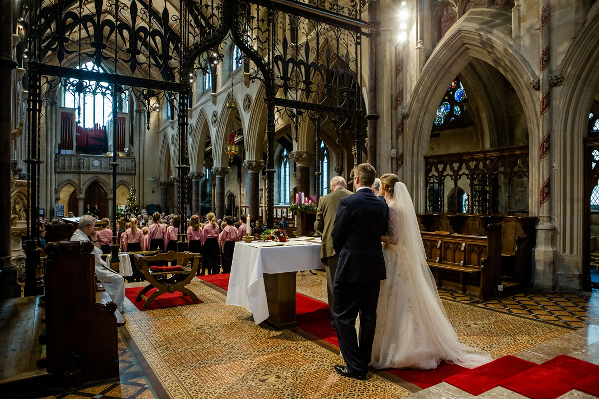 Katy wore a gold embroidered gown by Ronald Joyce for her glamorous winter wedding at Bath Assembly Rooms. Her bridesmaids wore navy blue. Photography by Lydia Stamps.