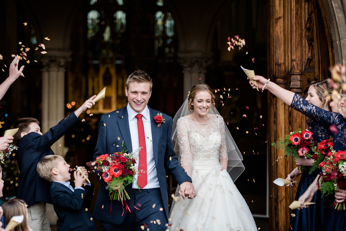 Katy wore a gold embroidered gown by Ronald Joyce for her glamorous winter wedding at Bath Assembly Rooms. Her bridesmaids wore navy blue. Photography by Lydia Stamps.