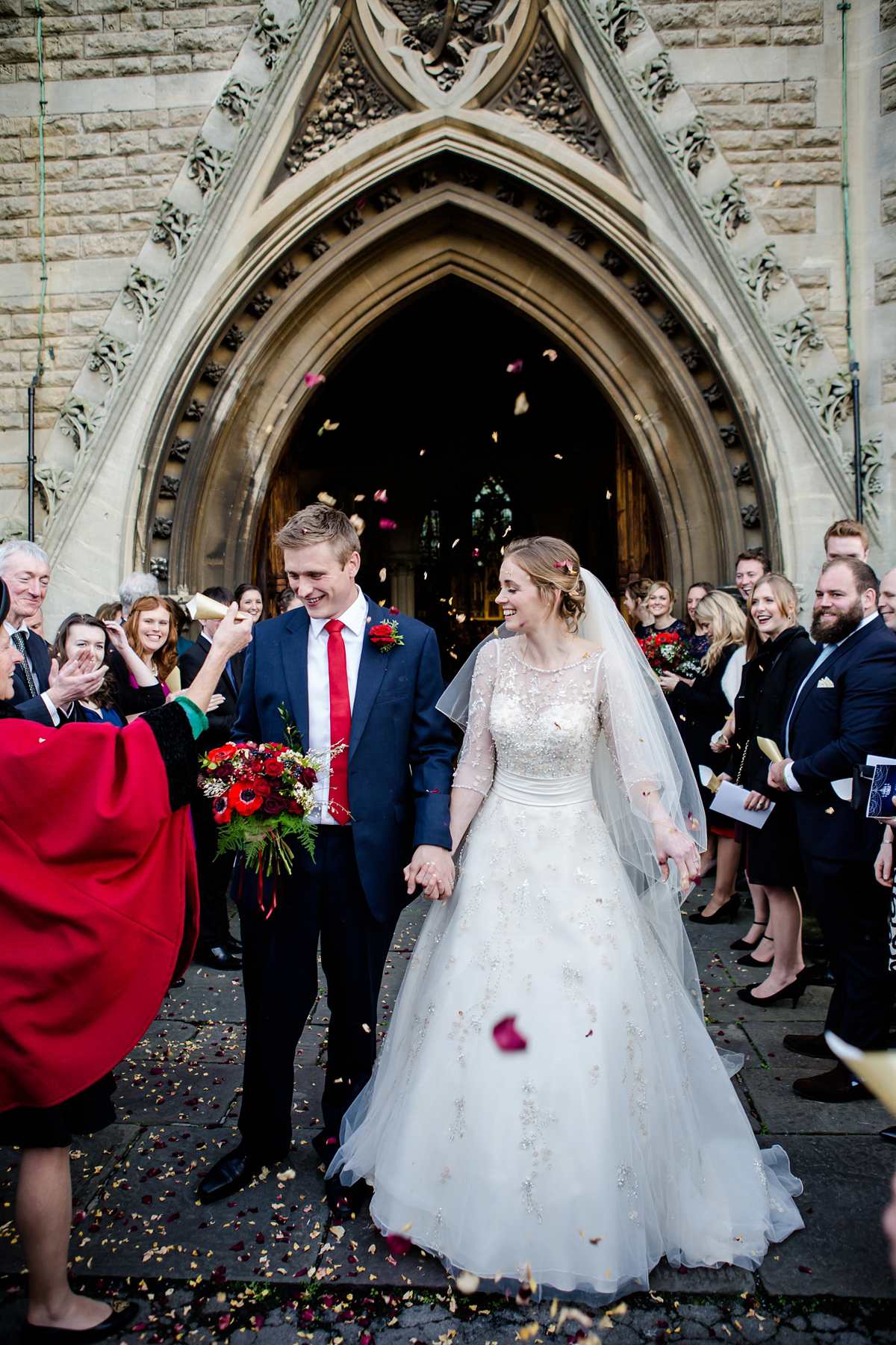 Katy wore a gold embroidered gown by Ronald Joyce for her glamorous winter wedding at Bath Assembly Rooms. Her bridesmaids wore navy blue. Photography by Lydia Stamps.