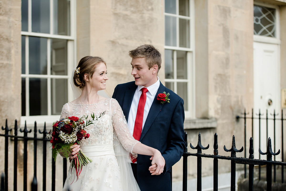 Katy wore a gold embroidered gown by Ronald Joyce for her glamorous winter wedding at Bath Assembly Rooms. Her bridesmaids wore navy blue. Photography by Lydia Stamps.