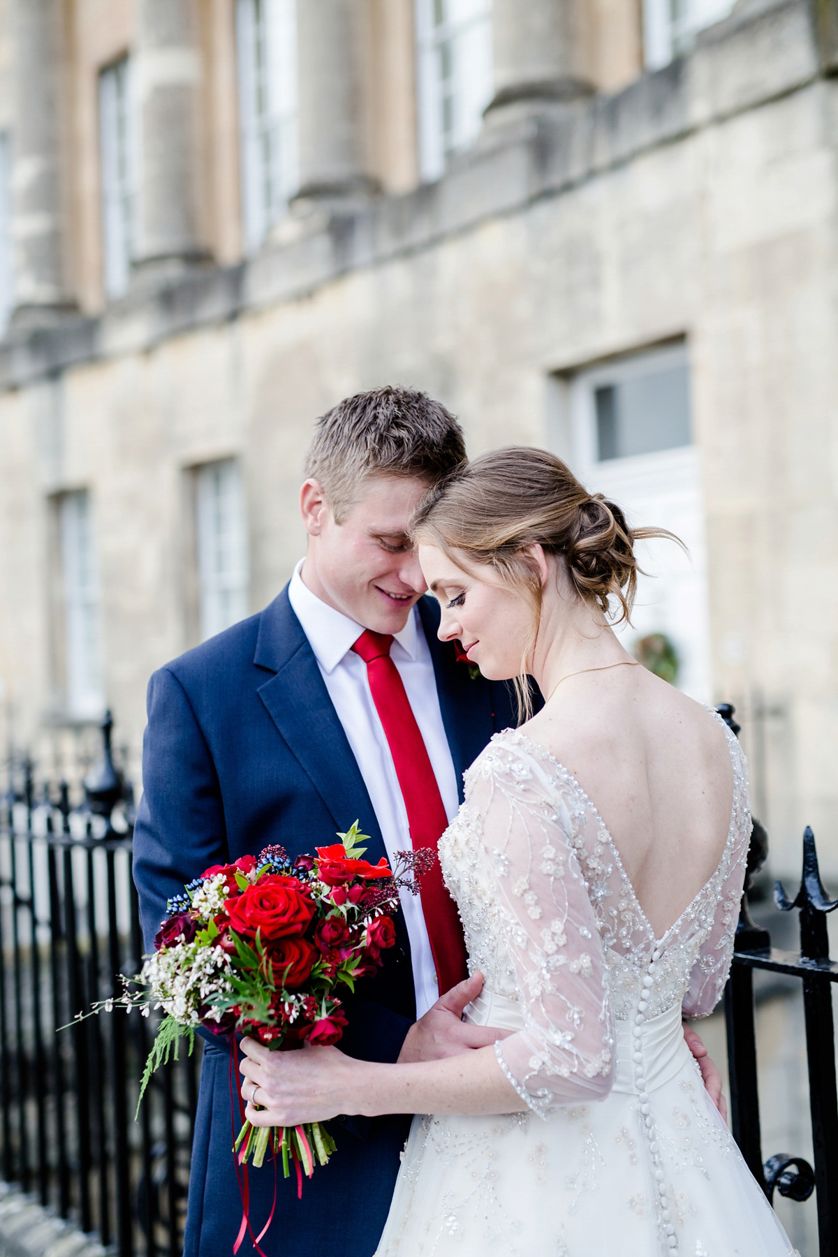 Katy wore a gold embroidered gown by Ronald Joyce for her glamorous winter wedding at Bath Assembly Rooms. Her bridesmaids wore navy blue. Photography by Lydia Stamps.