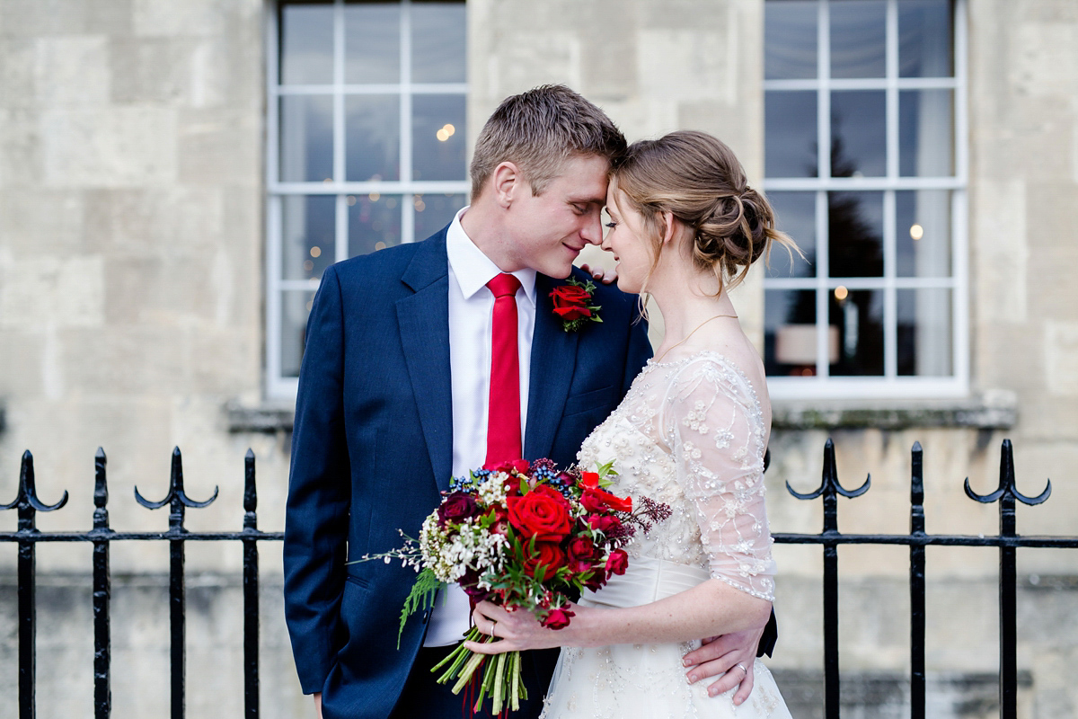 Katy wore a gold embroidered gown by Ronald Joyce for her glamorous winter wedding at Bath Assembly Rooms. Her bridesmaids wore navy blue. Photography by Lydia Stamps.