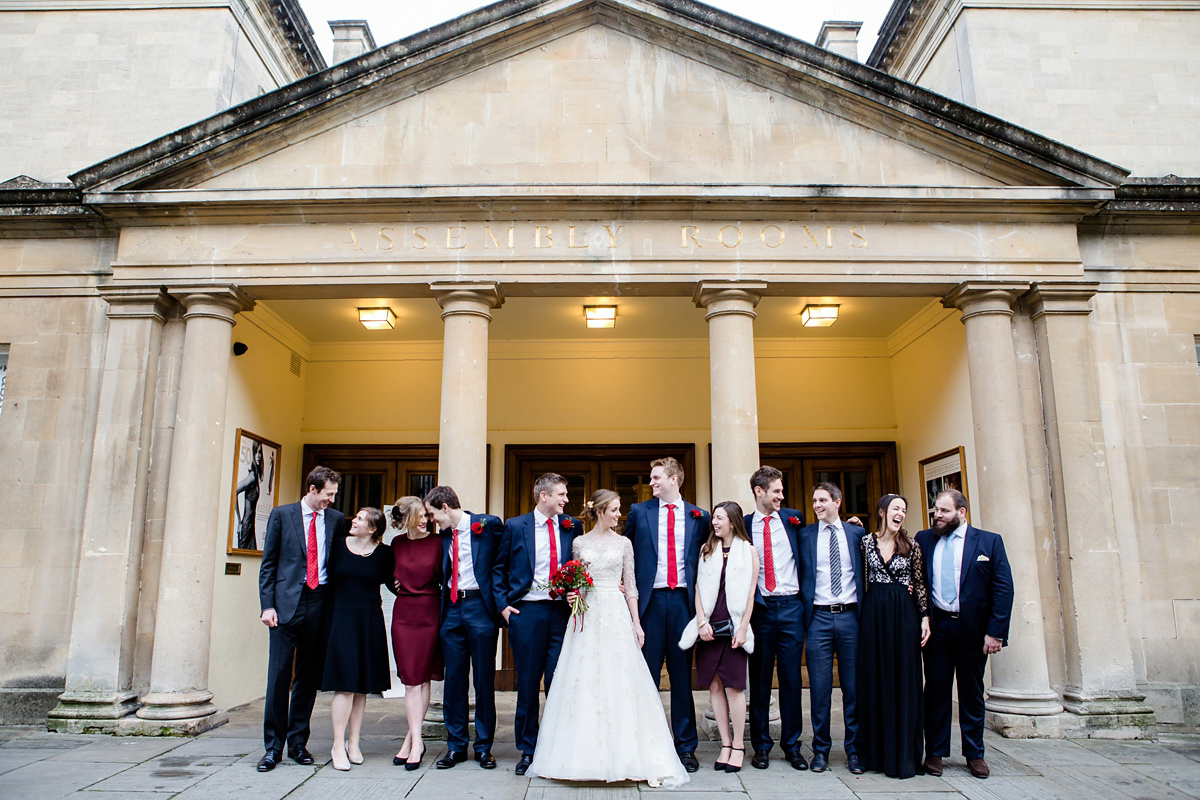 Katy wore a gold embroidered gown by Ronald Joyce for her glamorous winter wedding at Bath Assembly Rooms. Her bridesmaids wore navy blue. Photography by Lydia Stamps.