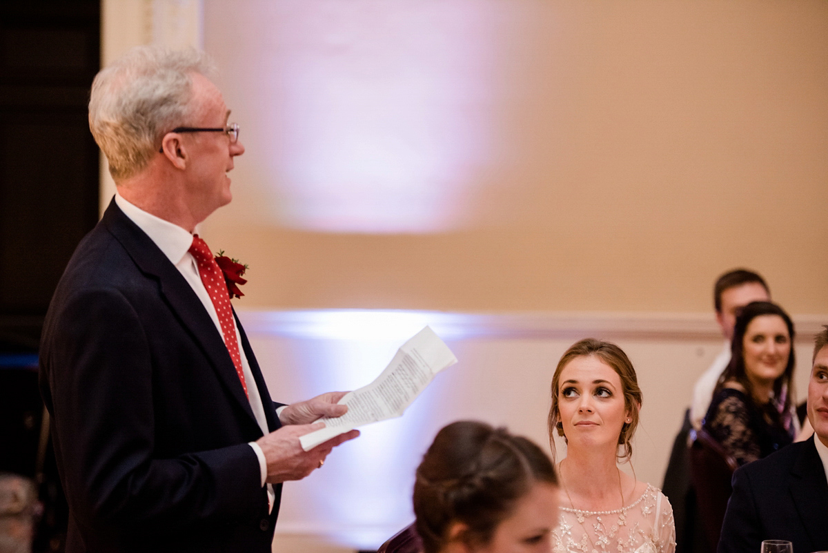 Katy wore a gold embroidered gown by Ronald Joyce for her glamorous winter wedding at Bath Assembly Rooms. Her bridesmaids wore navy blue. Photography by Lydia Stamps.