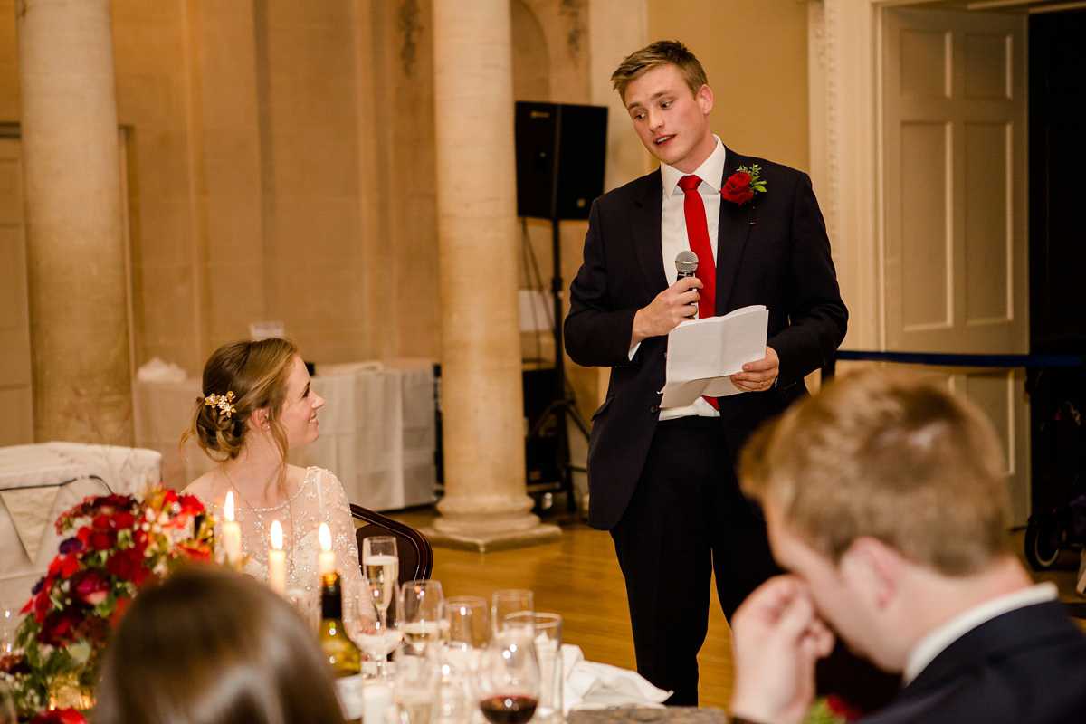 Katy wore a gold embroidered gown by Ronald Joyce for her glamorous winter wedding at Bath Assembly Rooms. Her bridesmaids wore navy blue. Photography by Lydia Stamps.