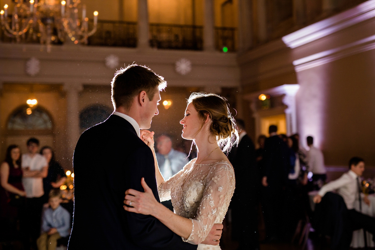 Katy wore a gold embroidered gown by Ronald Joyce for her glamorous winter wedding at Bath Assembly Rooms. Her bridesmaids wore navy blue. Photography by Lydia Stamps.