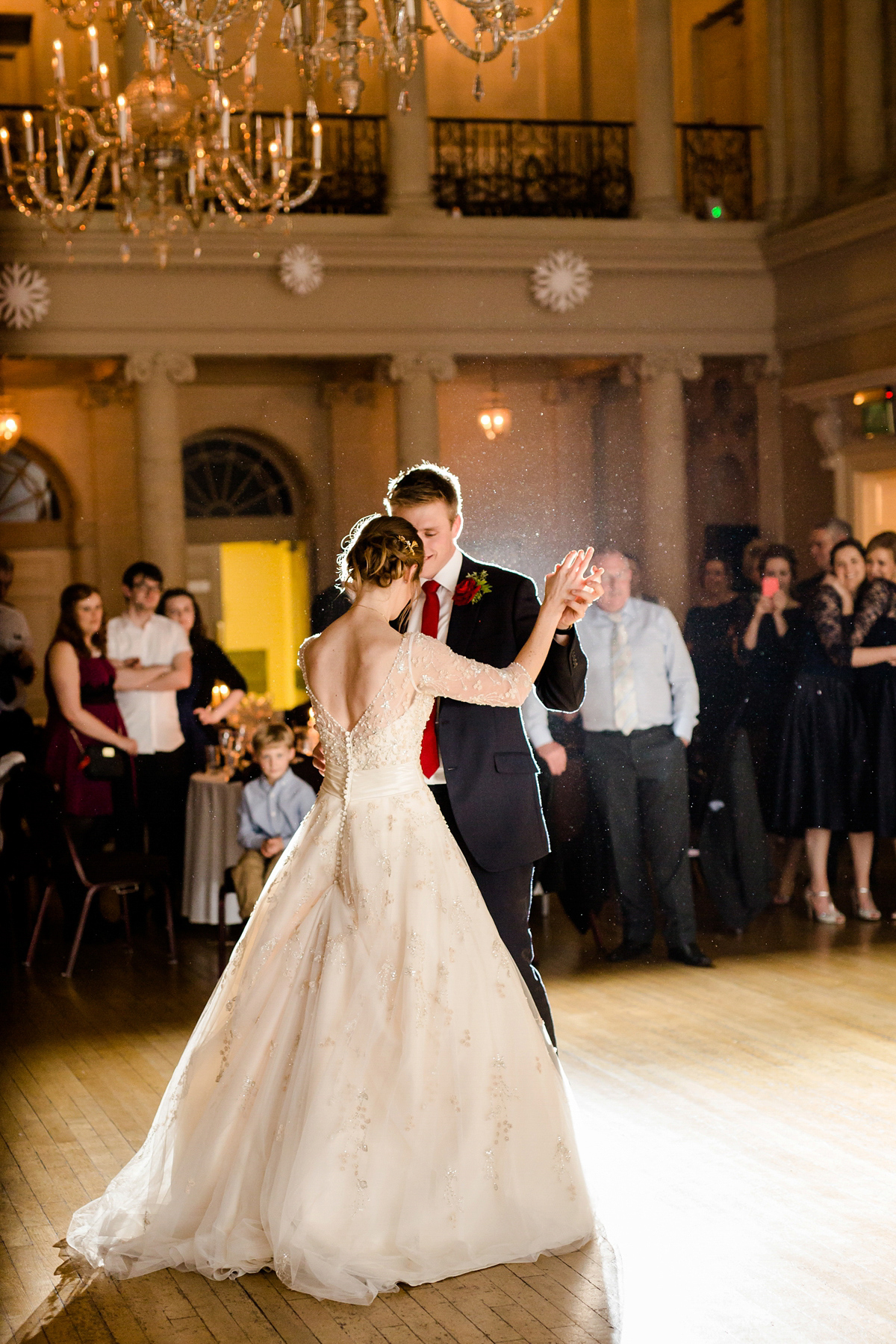 Katy wore a gold embroidered gown by Ronald Joyce for her glamorous winter wedding at Bath Assembly Rooms. Her bridesmaids wore navy blue. Photography by Lydia Stamps.