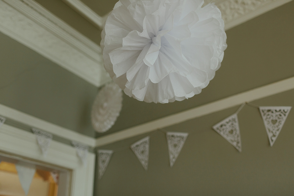 Berenice wore a 1930's vintage wedding dress for her intimate wedding held at home. The couple's ceremony involved a traditional Celtic handfasting. Photography by Rooftop Mosaic.