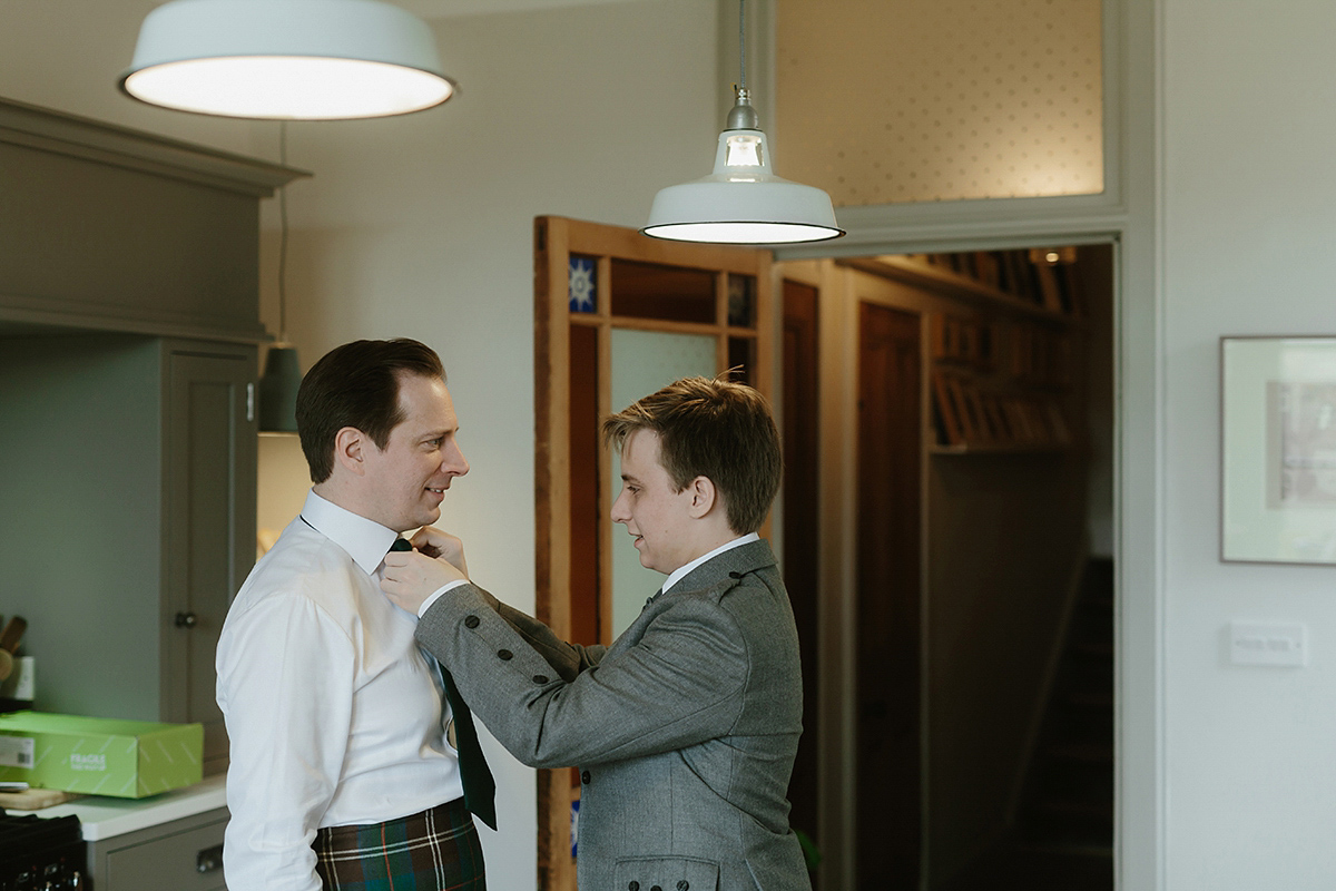 Berenice wore a 1930's vintage wedding dress for her intimate wedding held at home. The couple's ceremony involved a traditional Celtic handfasting. Photography by Rooftop Mosaic.